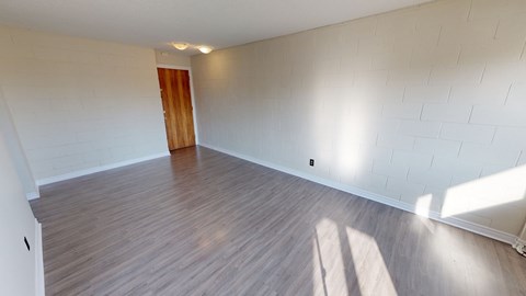 A room with wooden flooring and a door.